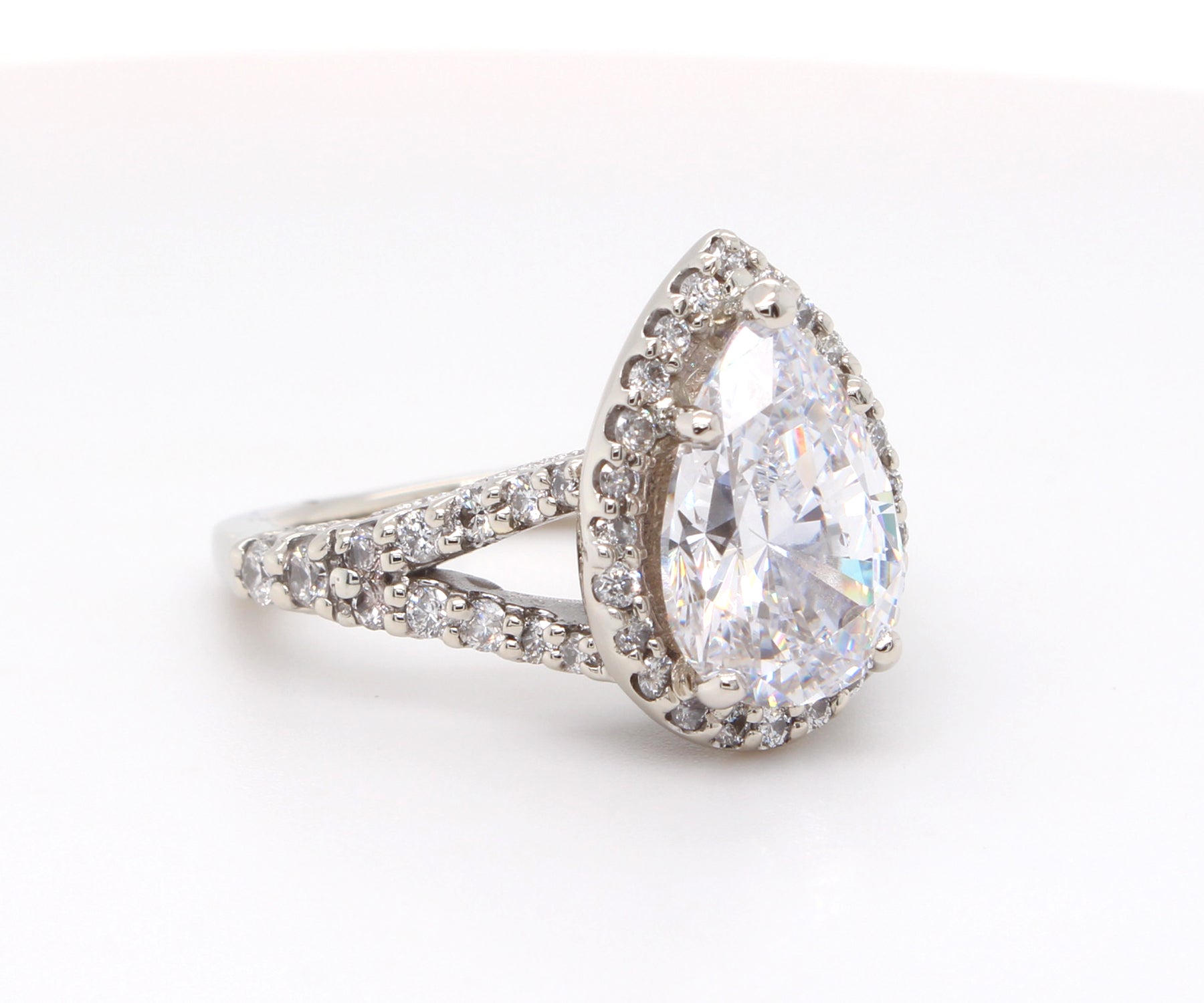 Impresionante anillo de diamantes divididos con halo en forma de pera