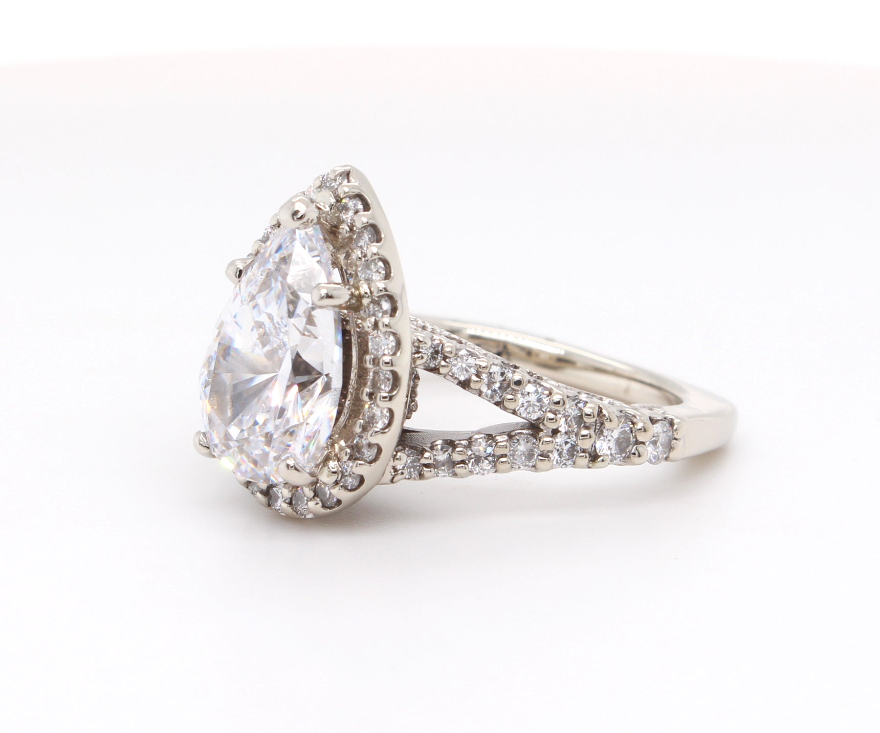 Impresionante anillo de diamantes divididos con halo en forma de pera