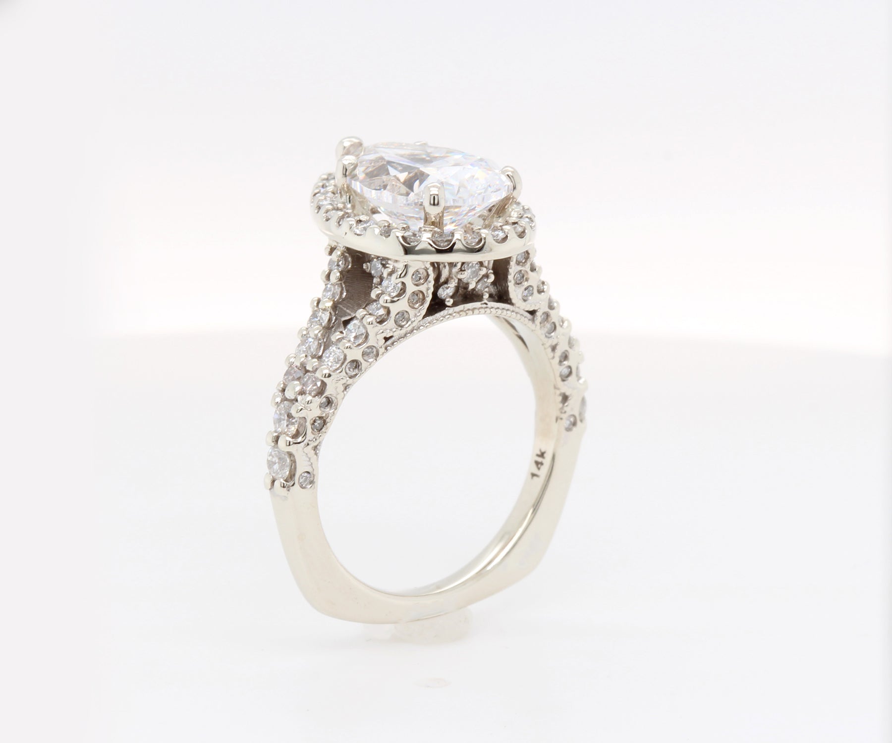 Impresionante anillo de diamantes divididos con halo en forma de pera