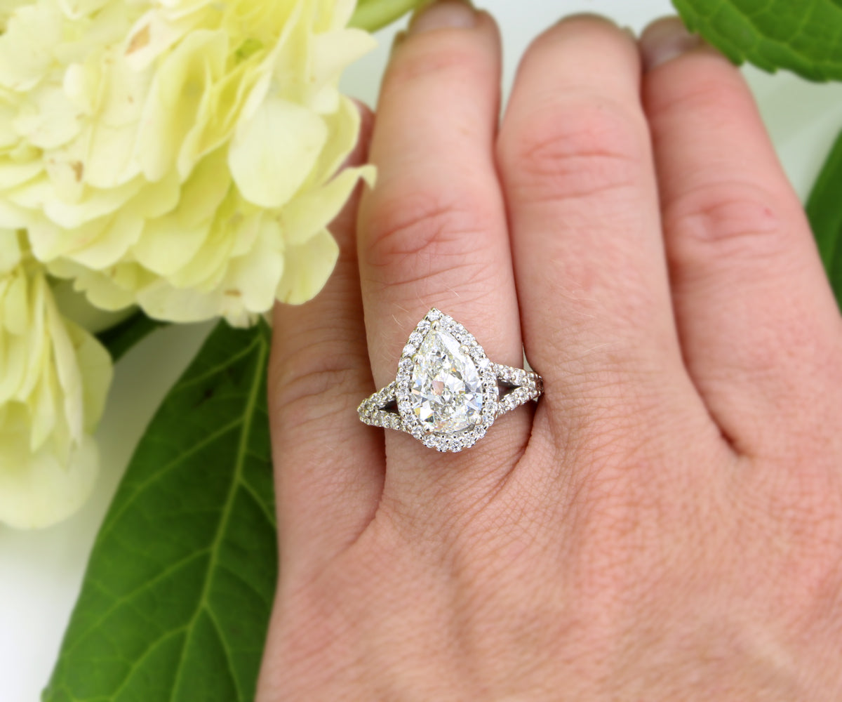 Impresionante anillo de diamantes divididos con halo en forma de pera