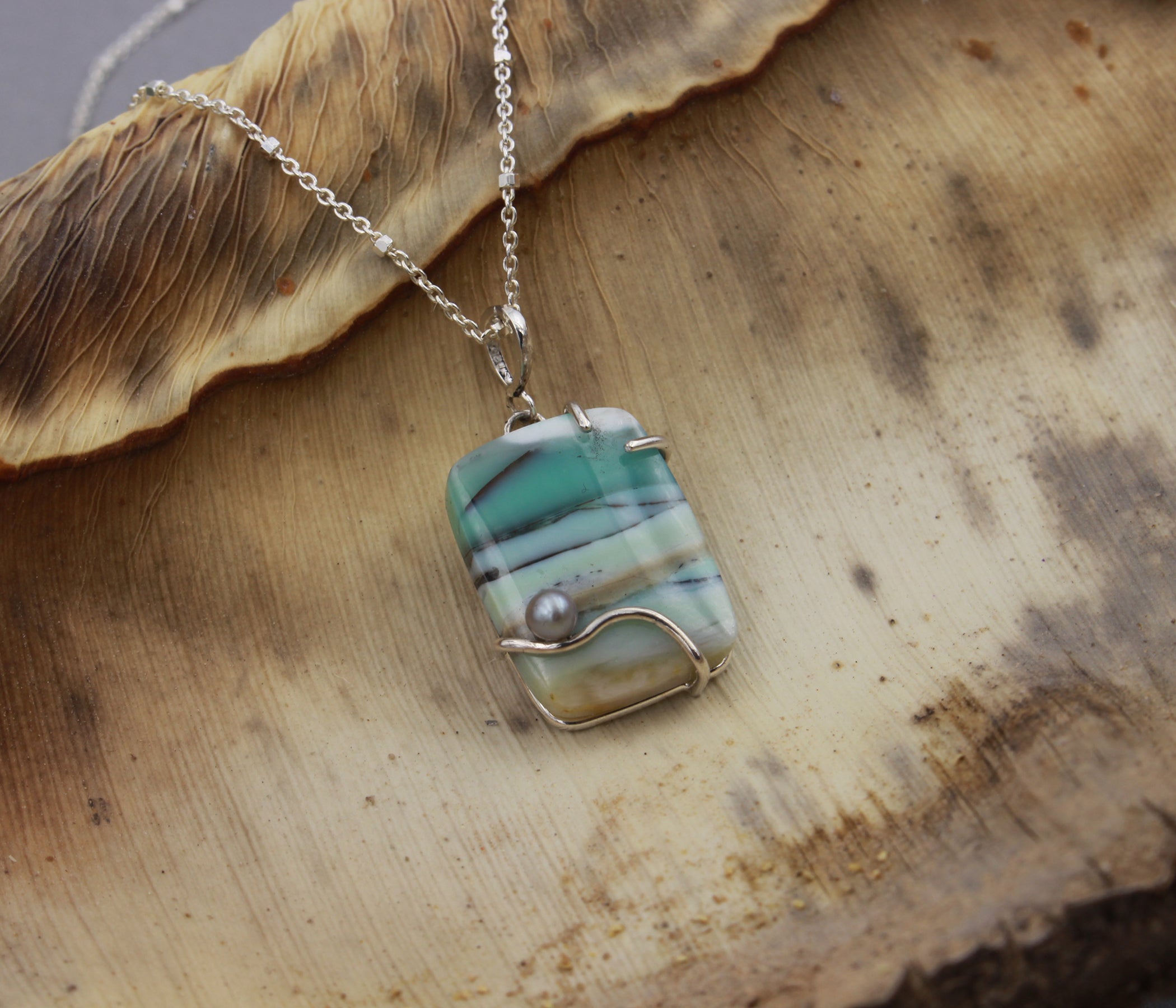 Collar artístico de madera petrificada con ópalo de playa