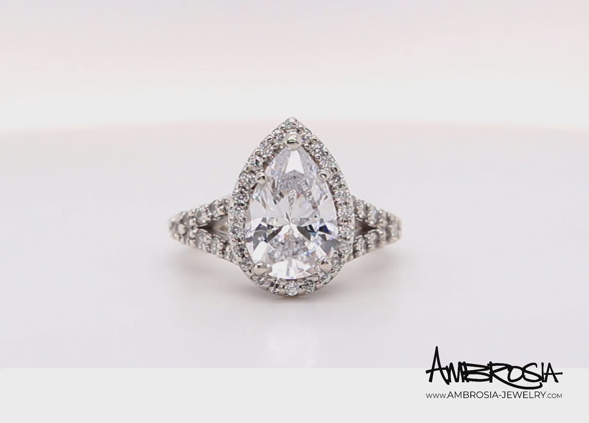 Impresionante anillo de diamantes divididos con halo en forma de pera