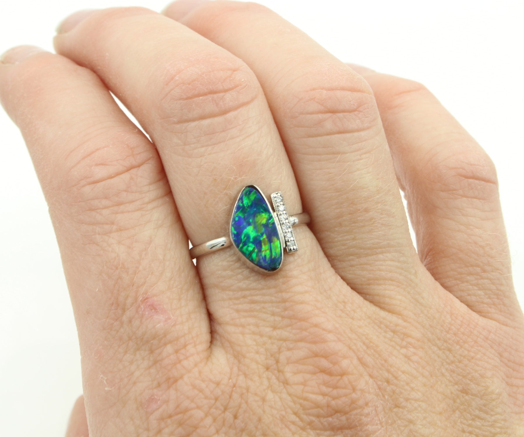 Anillo de oro blanco con barra de diamantes y ópalo negro