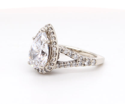 Impresionante anillo de diamantes divididos con halo en forma de pera