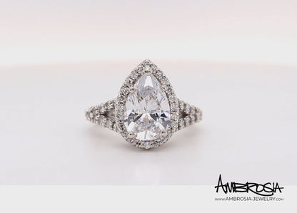 Impresionante anillo de diamantes divididos con halo en forma de pera