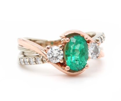 Anillo de oro rosa curvado con diamantes y tres piedras esmeralda
